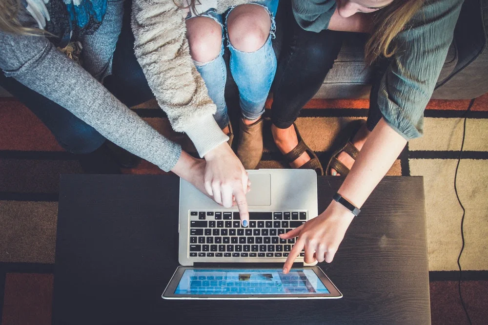 Students gathered around a laptop