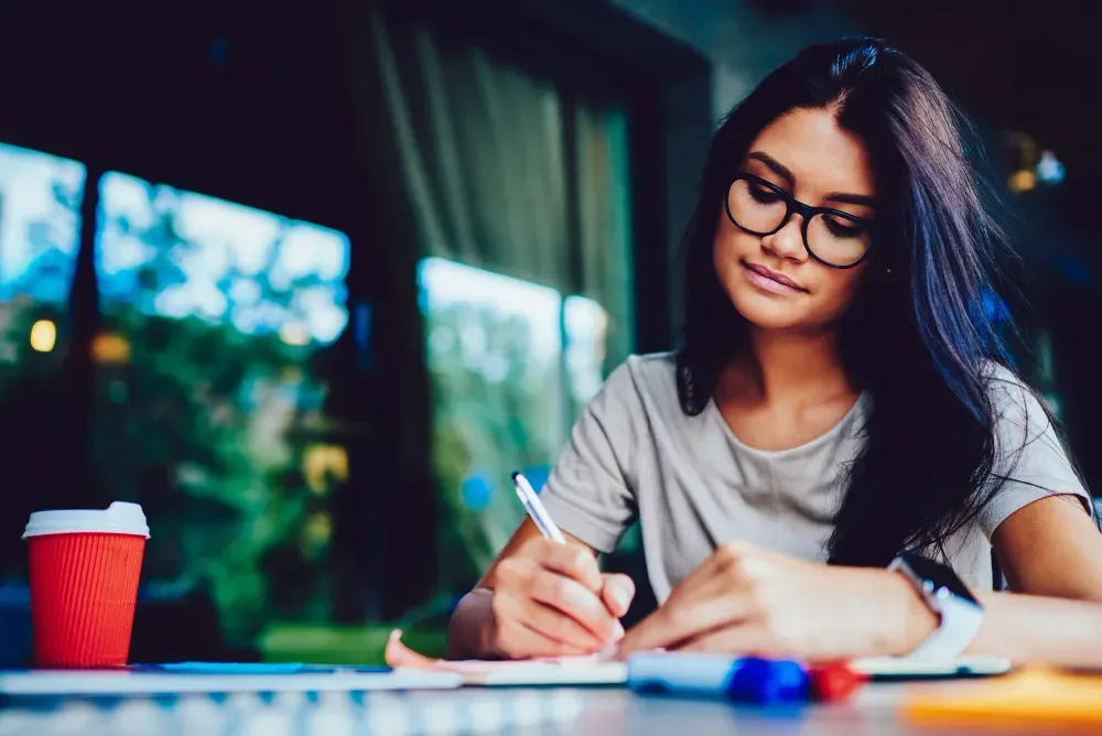 A student writing at a desk
